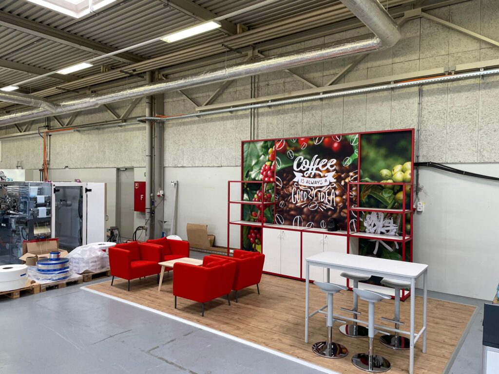 Perspective view of red T3 coffee stand with seating in front.